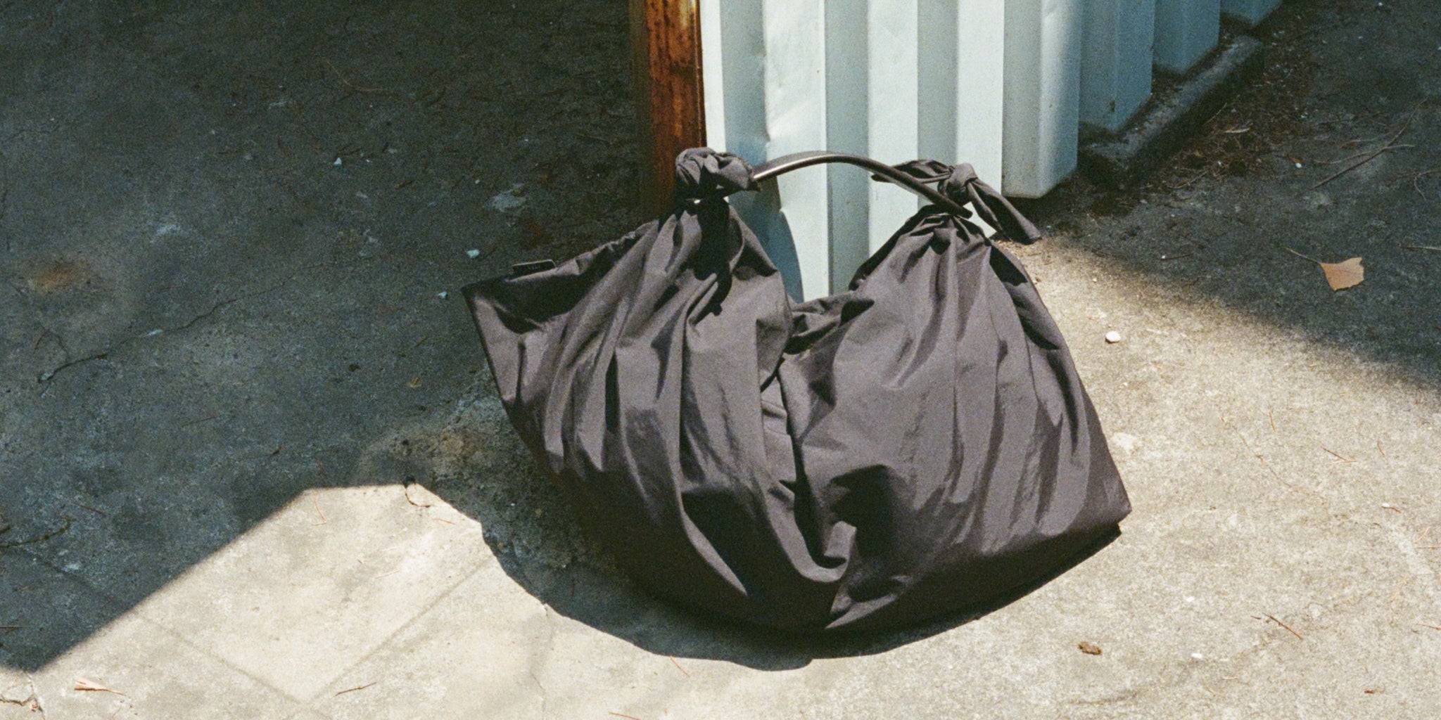 風呂敷に着想を得たITTIの新作バッグ〈HERRIE FUROSHIKI ONE HANDLE BAG〉。構造と素材が引き立つ、軽やかでミニマルな佇まいです。