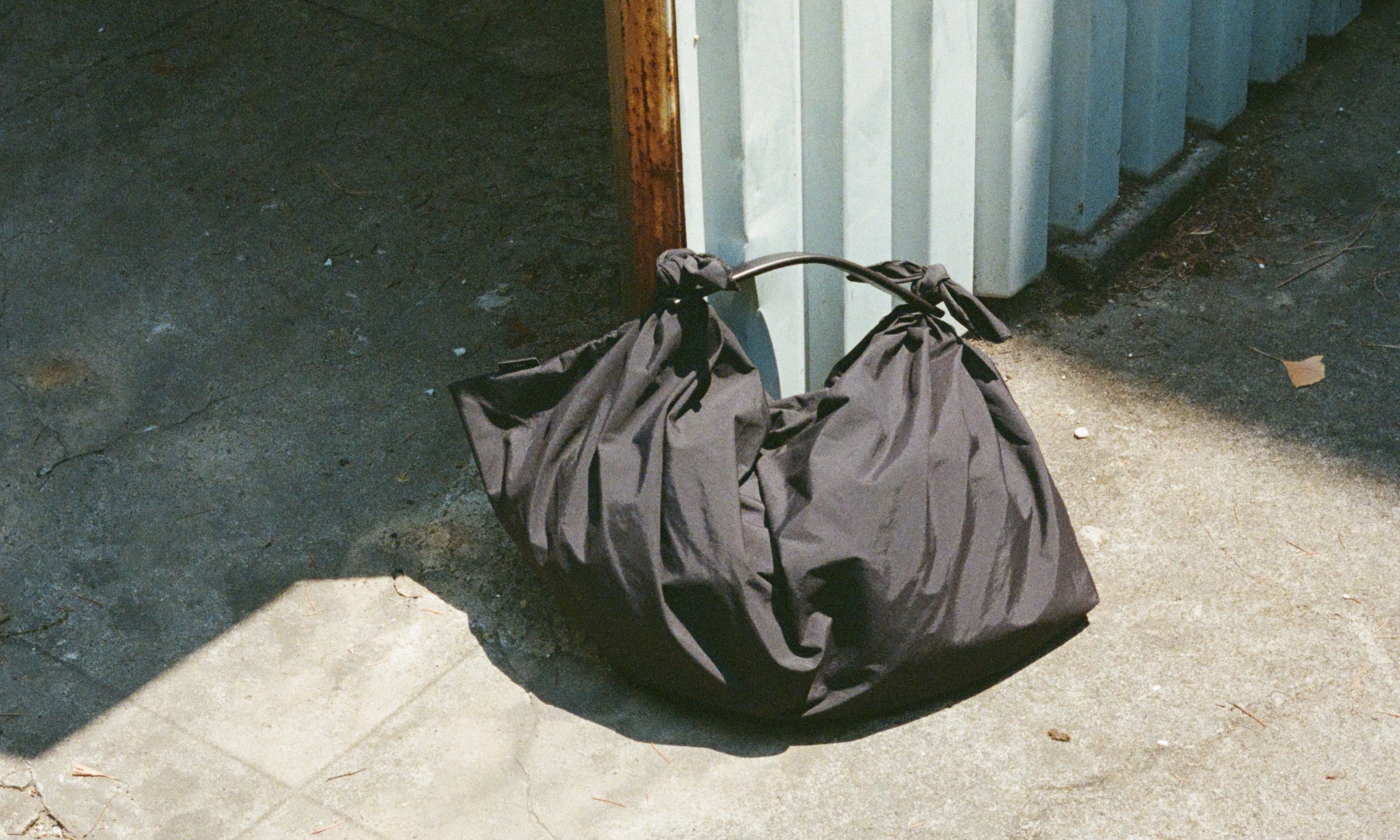 風呂敷に着想を得たITTIの新作バッグ〈HERRIE FUROSHIKI ONE HANDLE BAG〉。構造と素材が引き立つ、軽やかでミニマルな佇まいです。