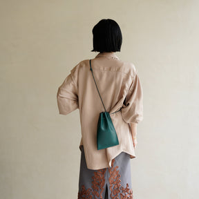 HERRIE KINCHAKU POUCH - PM / RAPTO FLEX｜ミニマル 巾着ポーチ 本革 ブラック メンズ レディース｜女性着用画像 スタイリング コーディネート｜ITTI（イッチ）公式