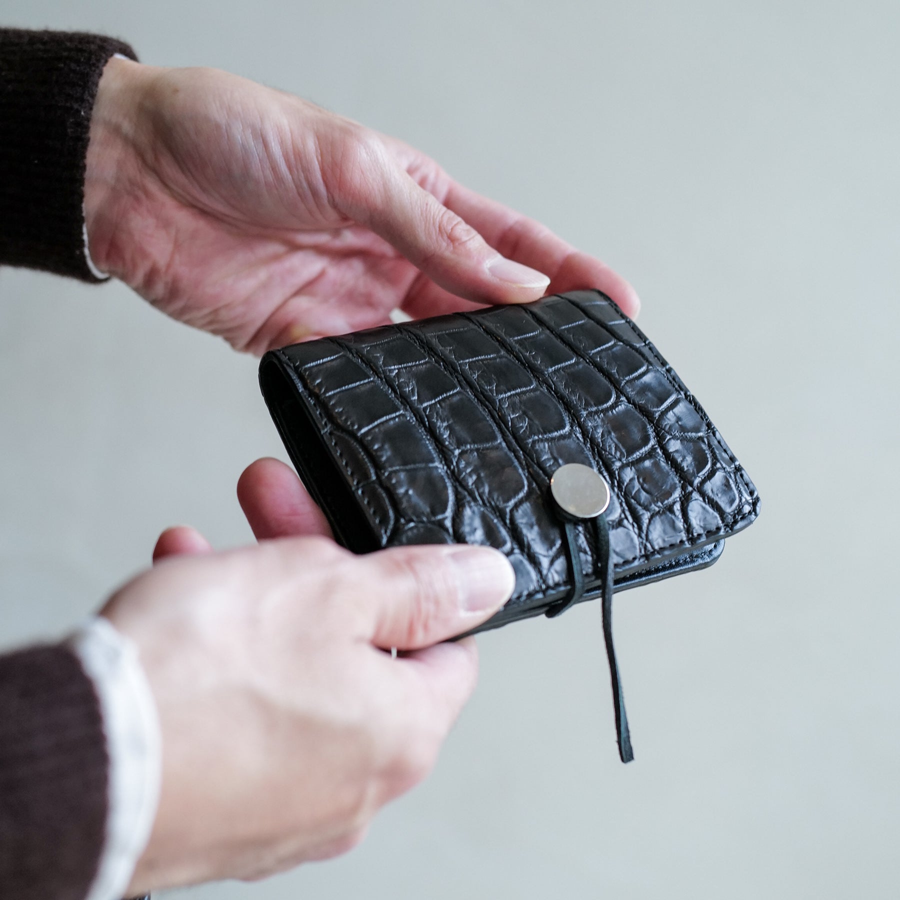 CRISTY WIND COMPACT WLT / CROCO｜クロコダイル ミニ財布｜ITTI（イッチ）公式｜メンズモデル 着用イメージ 手持ち画像