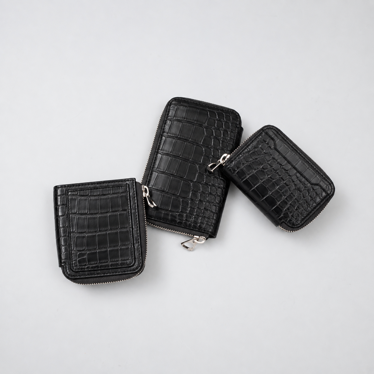 ブラックのCROCOを使ったITTIの3つの財布。部位による斑の違いが見える